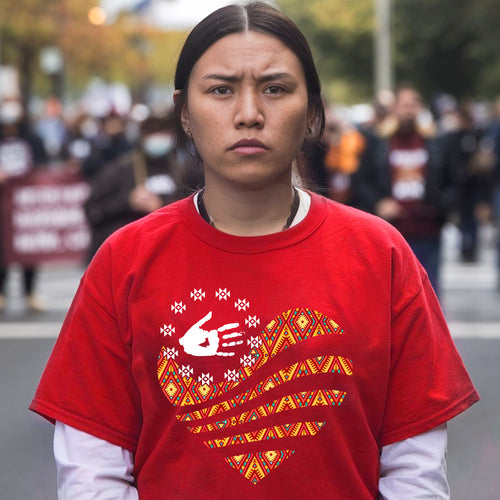 a woman in a red shirt is standing on the street