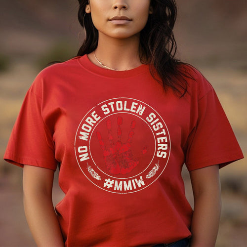 a woman wearing a red t - shirt that says no more stolen sisters on it