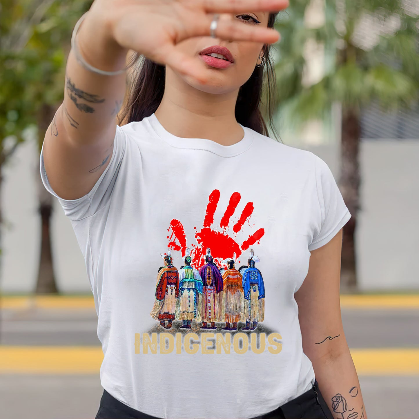 a woman wearing a white t - shirt with a red hand print on it