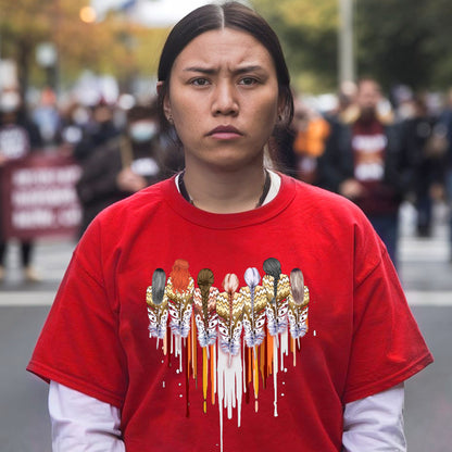 a woman in a red shirt is standing on the street