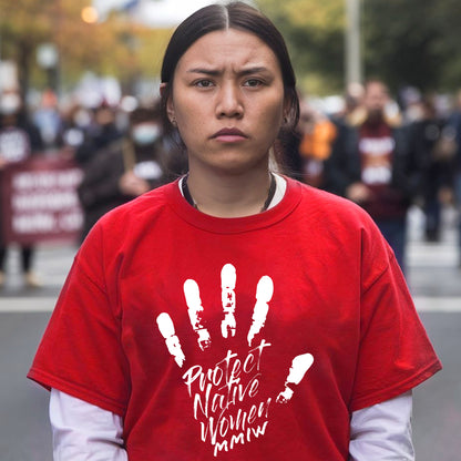 a woman in a red shirt is standing on the street