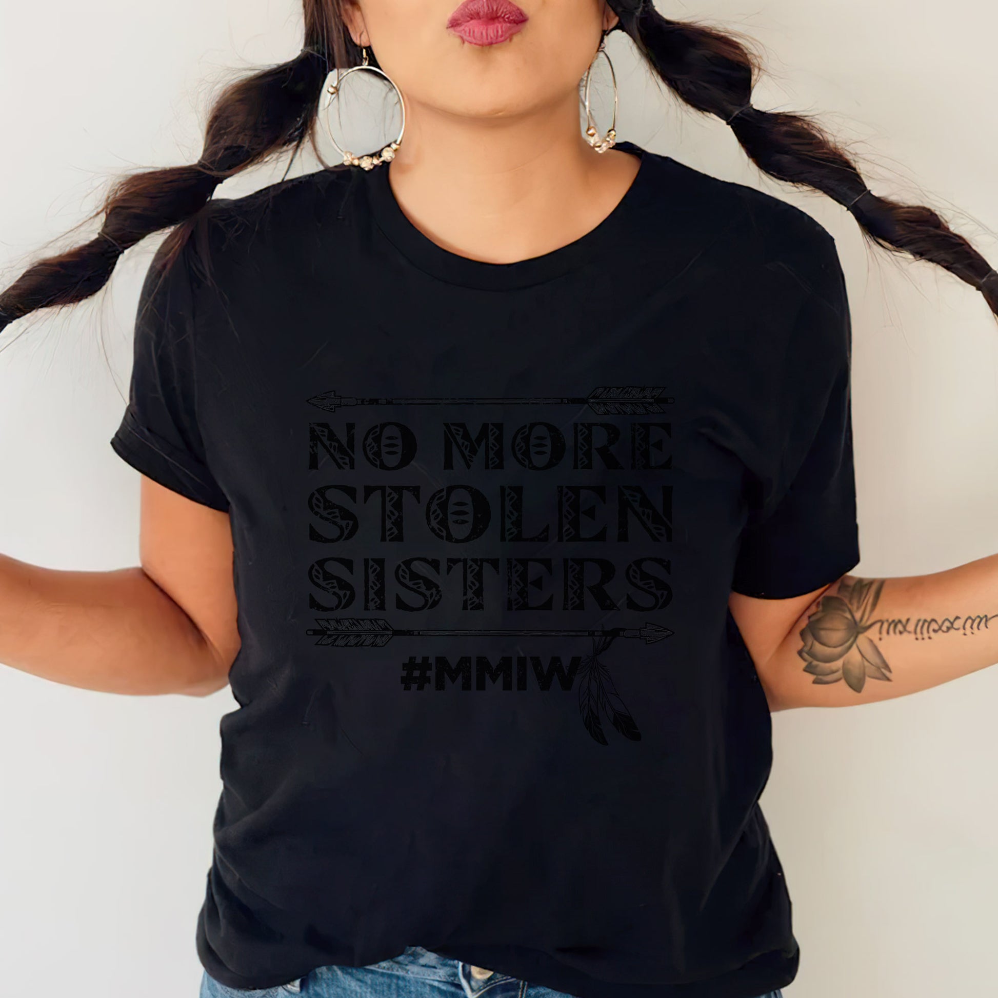 a woman wearing a black shirt that says no more stolen sisters