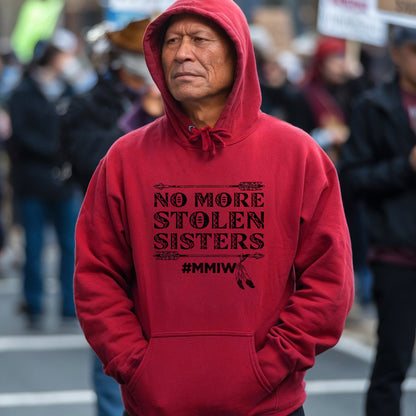 a man in a red hoodie is standing in the street