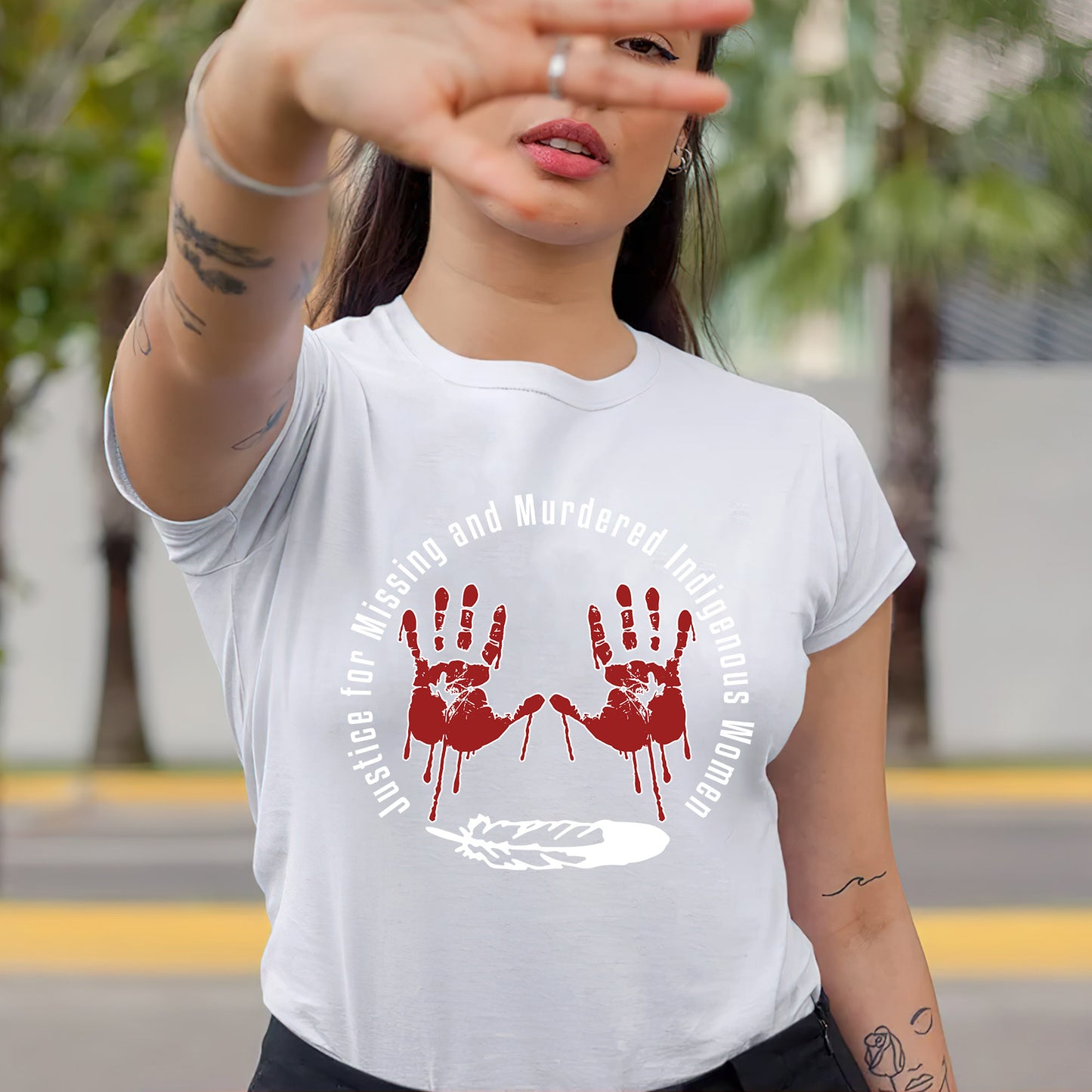 a woman wearing a white t - shirt with a red hand print