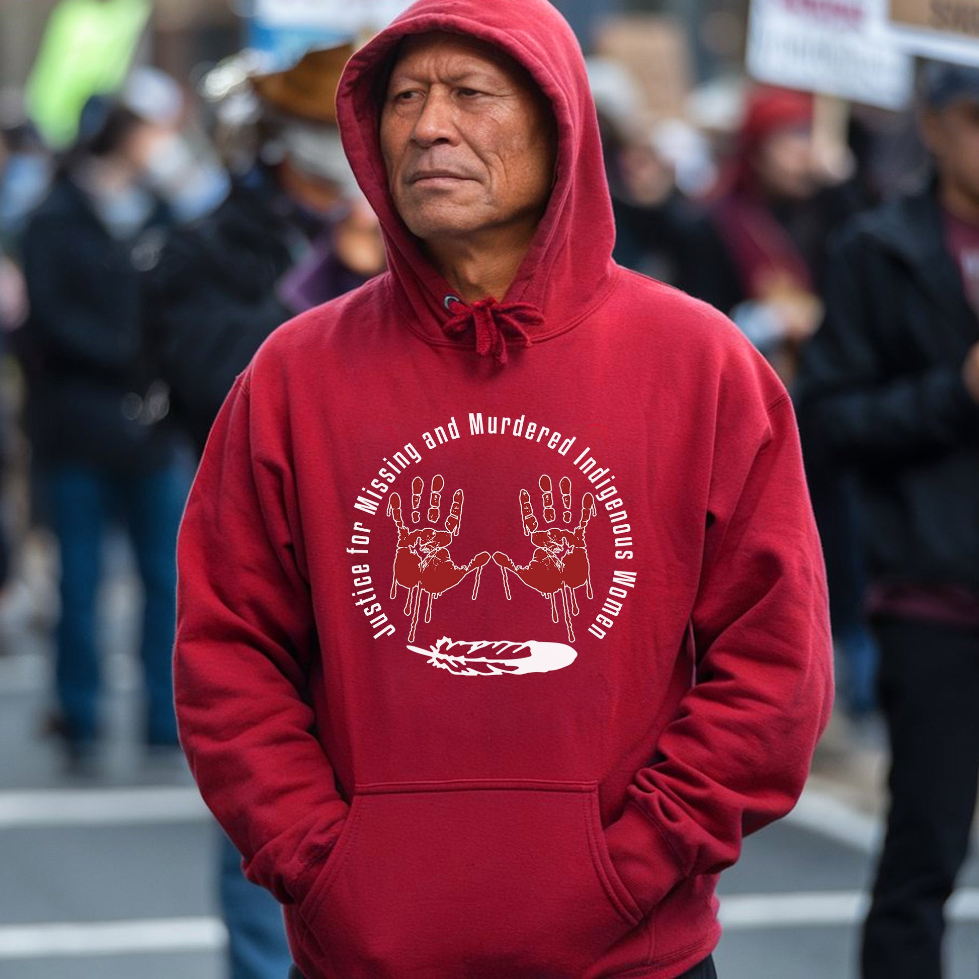 a man in a red hoodie stands in the middle of a street