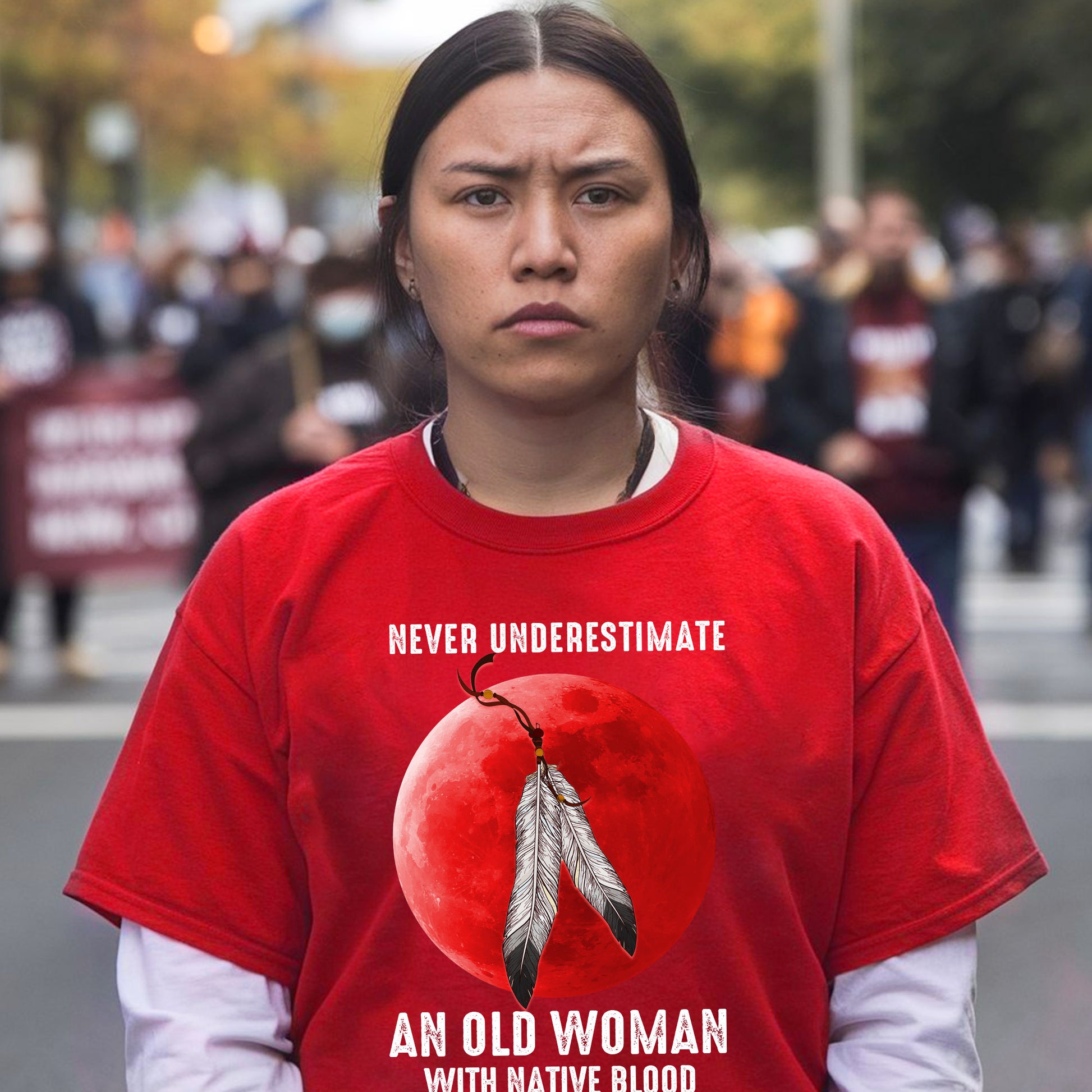 a woman wearing a red shirt with a feather on it